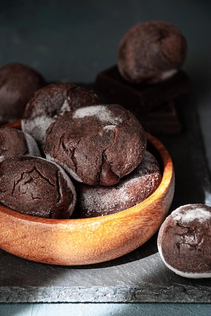 Een kom chocolademuffins met poedersuiker erop.