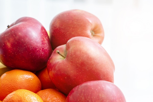 Een kom fruit op witte muur. Appels en sinaasappels