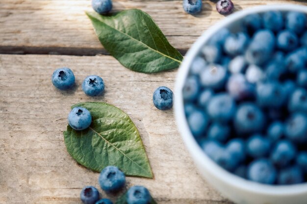 Een kom met verse bosbes Vaccinium myrtillus op een oude houten bank Verse bosbessen uit de tuin