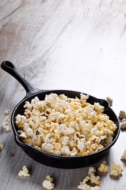 Een kom popcorn op een houten tafel