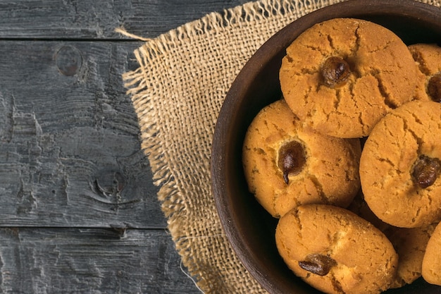 Een kom verse koekjes op een zwarte houten tafel