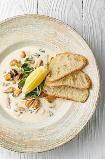 Een kom zeevruchtensoep met geroosterd brood en sint-jakobsschelpen