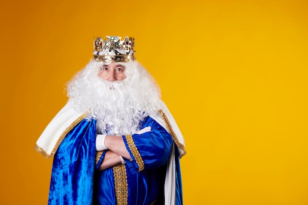 Een koning met wit haar en baard op een gele achtergrond