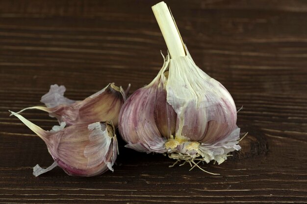 Een kop knoflook en twee plakjes op de achtergrond van een oude boom