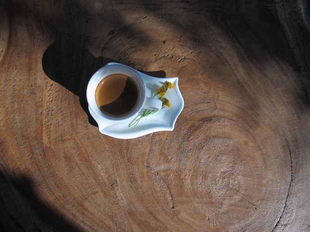 Foto een kop koffie op een houten tafel.