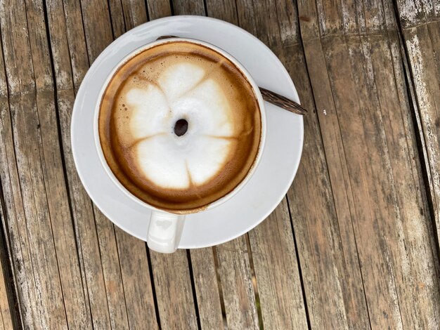 Foto een kop koffie op een houten tafel.