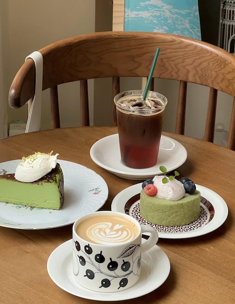 Een kop koffie zit op een tafel met een plak cake en een kop koffie.