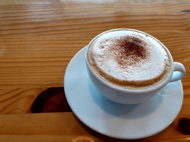 Een kop warme cappuccino koffie op de houten tafel.