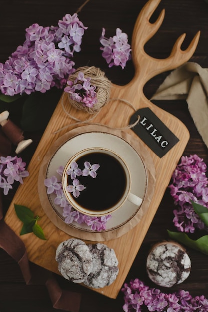 Een kopje americano zwarte koffie paarse lila bloemen op een houten achtergrond een kopje americano