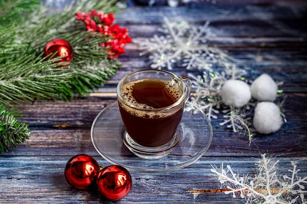 Een kopje aromatische koffie met bruine suiker, kerstversiering, takken van een kerstboom. Vakantieconcept Nieuwjaar. Op een houten achtergrond. Ruimte kopiëren.