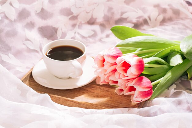 een kopje geurige versgemalen koffie met een vers boeket witroze tulpen