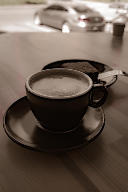 Een kopje koffie en een bord met dessert op een tafel in een café in vintage stijl Stadsleven