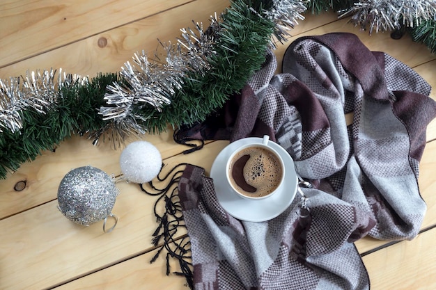 Een kopje koffie en een wintersjaal op een houten tafelclose-up