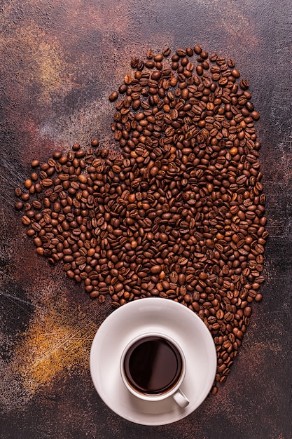 Een kopje koffie en koffiebonen gegoten in de vorm van een hart