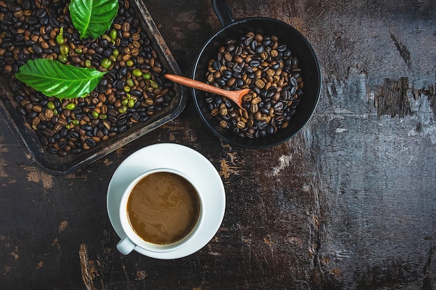 Een kopje koffie en koffiebonen op een houten tafel