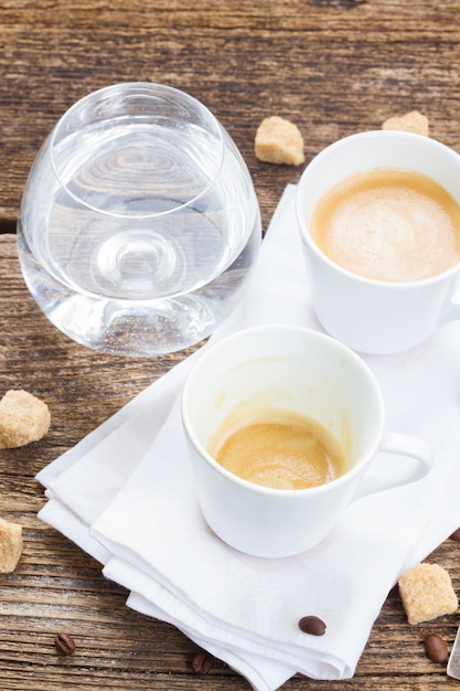 Een kopje koffie gedronken en een kopje verse esprasso met glas water