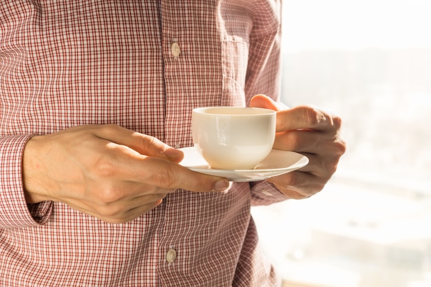 Een kopje koffie in de ochtend bij het raam