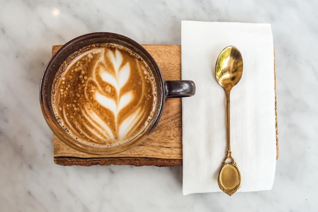 Een kopje koffie latte bovenaanzicht met bladvormig schuim