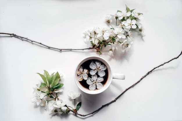 Een kopje koffie met bloeiende kersentakken