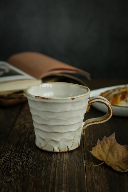 Een kopje koffie met een boek op tafel