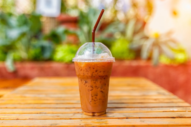 Een kopje koffie op een houten tafel in de tuin en zonnige bomen achtergrond