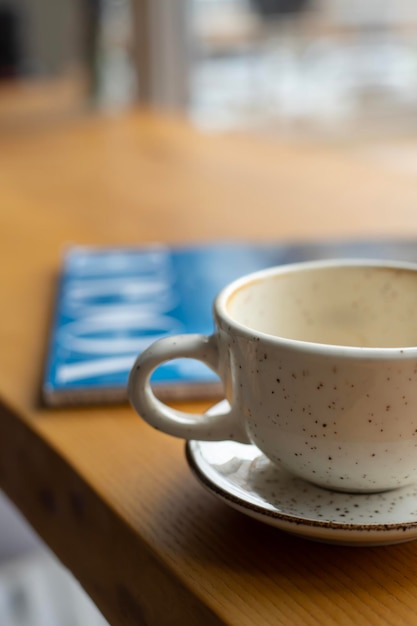 Een kopje koffie op een tafel in het interieur van een coffeeshop