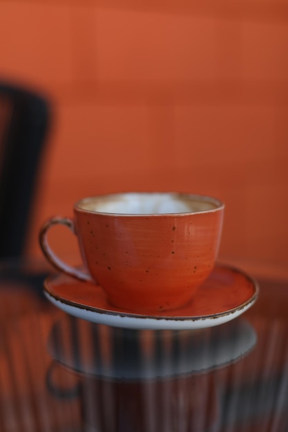 Een kopje koffie op glazen tafel in de ochtend