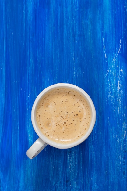 Een kopje koffie op oude blauwe houten oppervlak