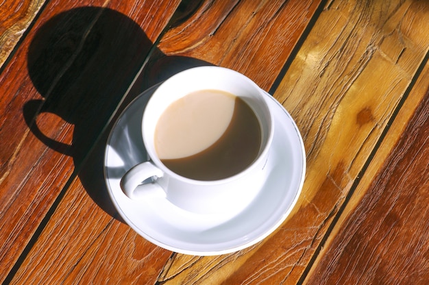 Een kopje koffiemelk op houten tafel