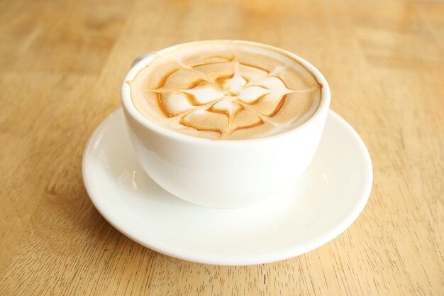 Een kopje late koffie met bloemvorm erop in het café