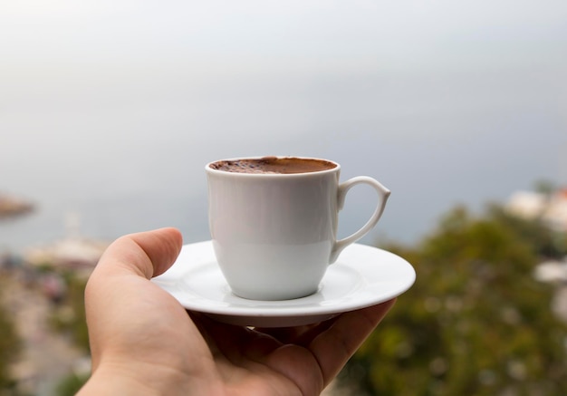 Een kopje turkse koffie op de achtergrond van een uitzicht op zee