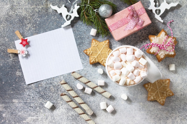 Een kopje warme chocolademelk met marshmallows en kerstgebak op een stenen aanrecht Bovenaanzicht
