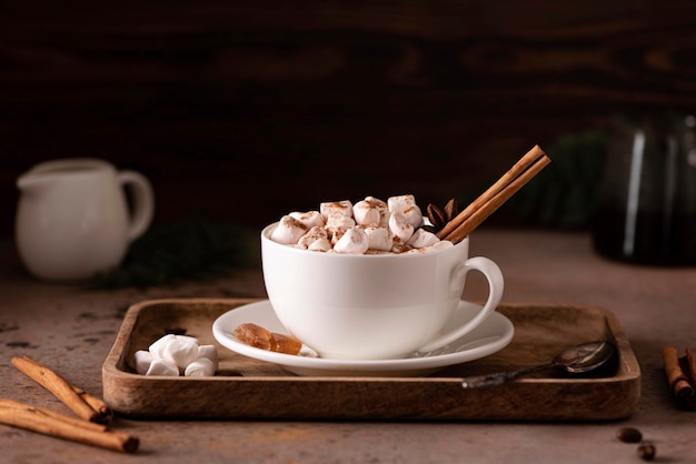 een kopje zwarte hete koffie met kaneel en marshmallows op een houten dienblad, close-up