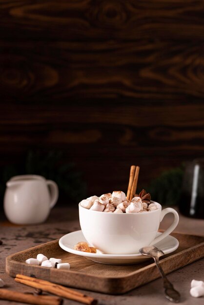 een kopje zwarte koffie met kaneel en marshmallows op een houten dienblad, close-up