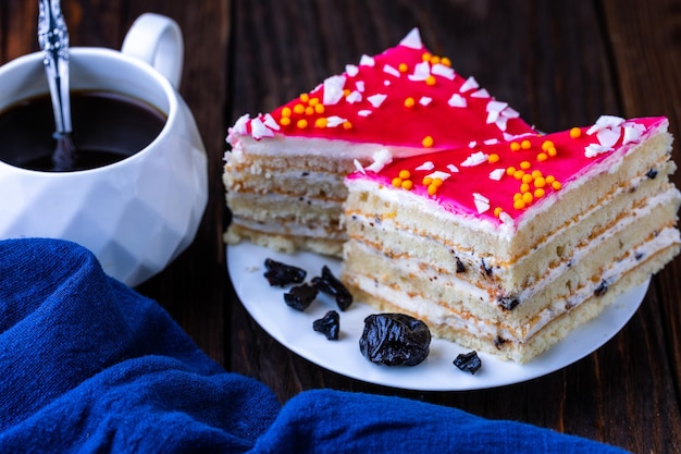 Een kopje zwarte thee en een bord met zelfgemaakte bakkerijkoekjes op een houten tafel