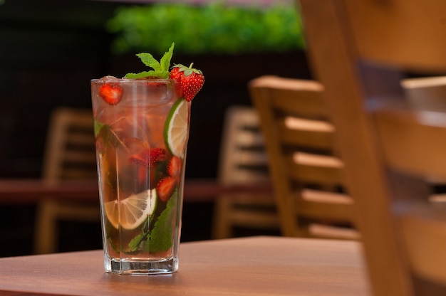 Een koud drankje met citrus en aardbeien in een glas op tafel