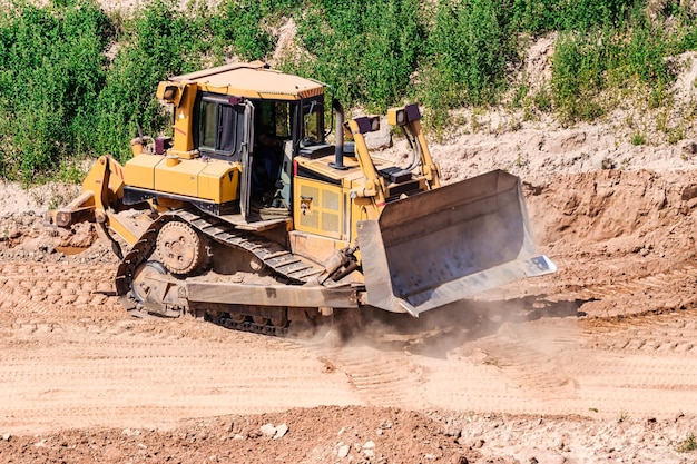 Een krachtige bulldozer in een zandbak plant een terrein Winning van zand in een open put natuurlijke bouwmaterialen