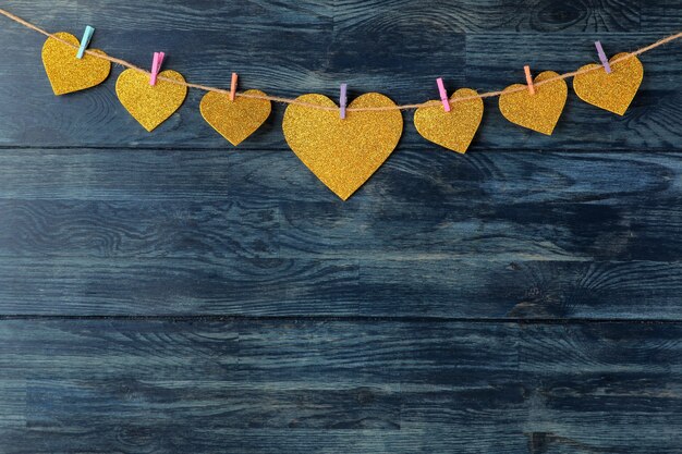 Een krans van harten op wasknijpers op een blauwe houten achtergrond Valentijnsdag.