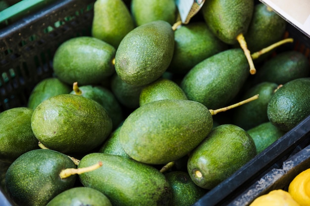 Een krat van rijpe groene avocado&#39;s in de supermarkt