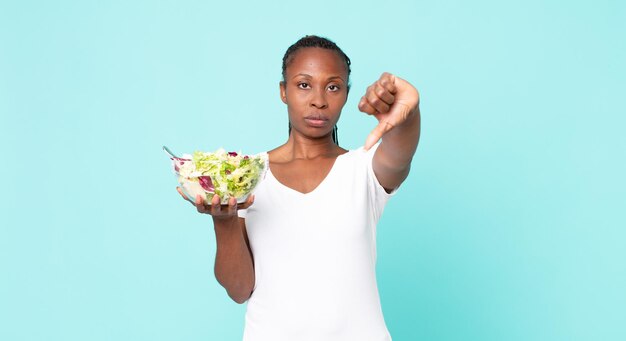 Een kruis voelen duimen naar beneden laten zien en een salade vasthouden