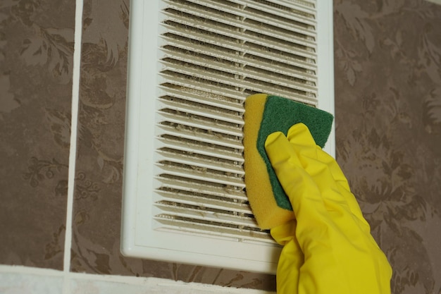 Een laag stof op het ventilatierooster Stof wordt afgeveegd met een spons