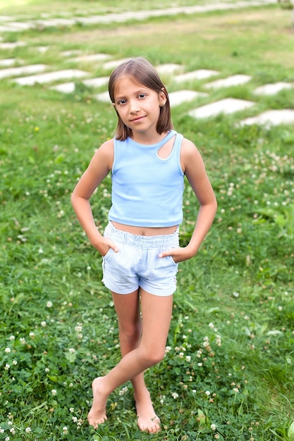 Een lachend meisje op het groene gras in het stadspark op een zomerdag. buiten wandelingen.