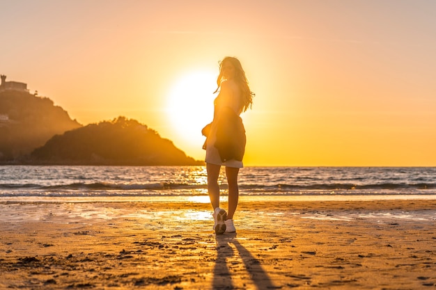 Een lachende blondine met grijze pullover tijdens een lifestyle-sessie op het strand