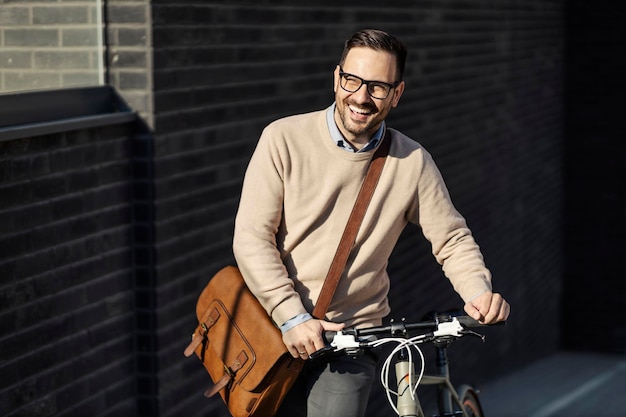 Een lachende man die fiets duwt terwijl hij buiten loopt