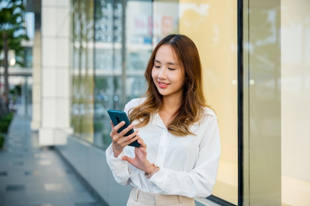 Een lachende vrouw gebruikt haar smartphone buiten