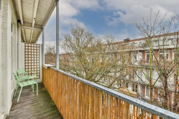 Een lang balkon met een rieten schutting en uitzicht op de stadsgebouwen