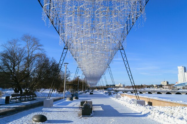 Een lange slinger over een voetpad in een winterse stad en een blauwe lucht