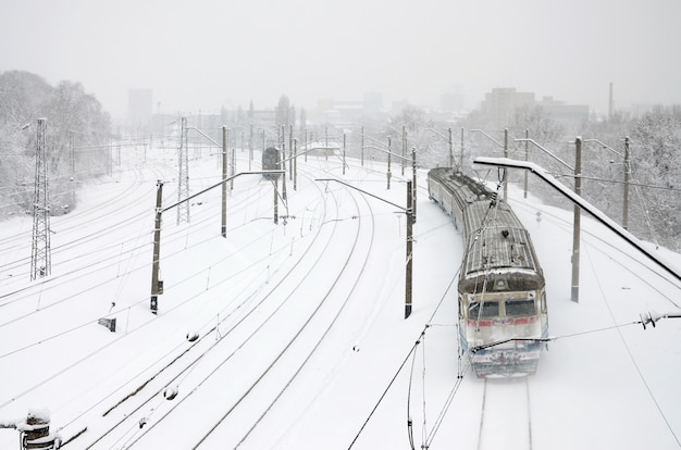 Een lange trein van personenauto&#39;s rijdt over het spoor