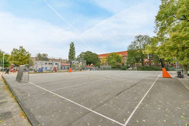 Een leeg basketbalveld in een park met bomen