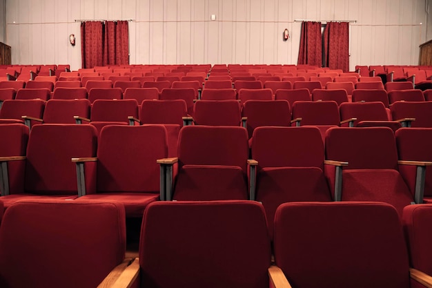 Een lege bioscoopzaal tijdens een lockdown het theater staat in quarantaine sluiting van bioscopen de afwezigheid van toeschouwers in de bioscoop rode lege stoelen in het theater